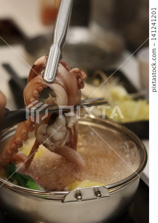 Chef Trimming Octopus Tentacles Over Simmering Pot Chef Trimming Octopus Tentacles Over Simmering Pot 141241201