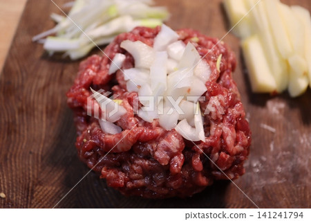 Raw Ground Beef with Onions and Vegetables on Cutting Board Raw Ground Beef with Onions and Vegetables on Cutting Board 141241794