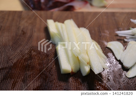 Sliced Apple Sticks on Wooden Cutting Board 141241820