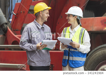 Two engineers discussing project together with construction worker outdoors Two engineers discussing project together with construction worker outdoors 141241984