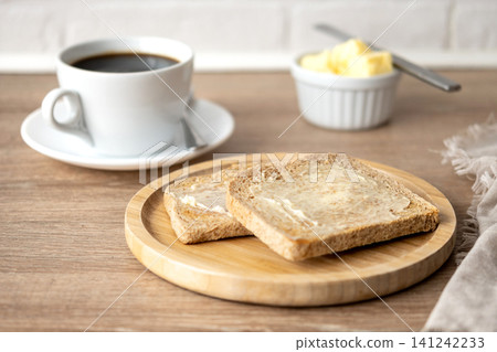 Buttered whole wheat toast with black coffee for breakfast Buttered whole wheat toast with black coffee for breakfast 141242233