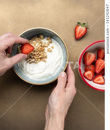 Woman hand preparing healthy breakfast yogurt Woman hand preparing healthy breakfast yogurt 141242647