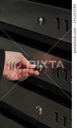 Vertical video Close-up woman is opening her mailbox and taking out of her mail in her apartment building. Mail shipping concept. Vertical video Close-up woman is opening her mailbox and taking out of her mail in her apartment building. Mail shipping concept. 141243194