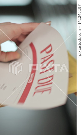 Vertical video Close up woman is opening envelope with Payment notification letter while standing in front of mailboxes in her apartment building. Mail shipping concept. Vertical video Close up woman is opening envelope with Payment notification letter while standing in front of mailboxes in her apartment building. Mail shipping concept. 141243197