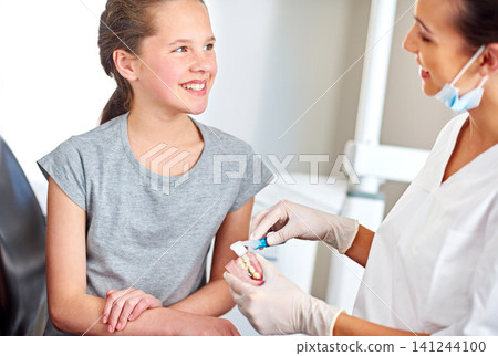 Dentures, child and orthodontics with toothbrush for teaching on oral hygiene, gum disease and dental care. Consultation, young girl and dentist holding teeth for cleaning, treatment and wellness 141244100