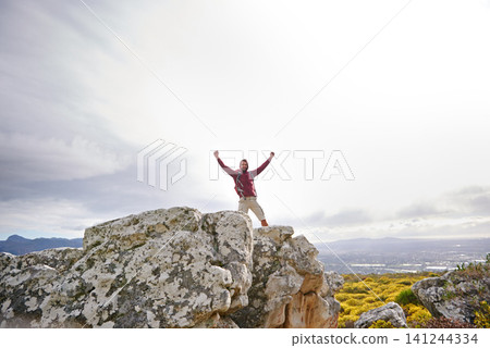 Motivation, success and man with winner on mountain, nature and rock for outdoor adventure. Male person, athlete and sport in environment for exercise, fitness and health with happiness by landscape Motivation, success and man with winner on mountain, nature and rock for outdoor adventure. Male person, athlete and sport in environment for exercise, fitness and health with happiness by landscape 141244334