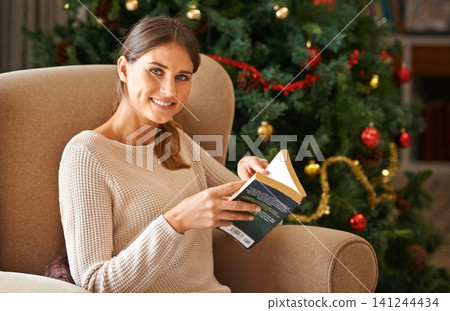 Portrait, book and woman on sofa for Christmas, celebration and religious holiday at home in living room. Female person, lady and novel for reading in house, apartment and lounge in Canada with smile Portrait, book and woman on sofa for Christmas, celebration and religious holiday at home in living room. Female person, lady and novel for reading in house, apartment and lounge in Canada with smile 141244434