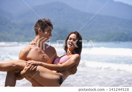 Beach, man carrying woman and ocean for travel, anniversary or date with bonding, love and support. Happy, freedom and fresh air in nature, couple outdoor and laughter, trust and hug in relationship Beach, man carrying woman and ocean for travel, anniversary or date with bonding, love and support. Happy, freedom and fresh air in nature, couple outdoor and laughter, trust and hug in relationship 141244528