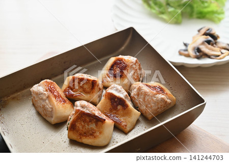 Minced meat stuffed into fish cake, fried in a frying pan. 141244703