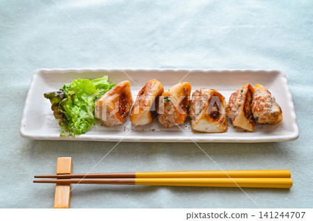 Grilled fish cake stuffed with minced meat, flavored with mentsuyu (noodle soup base). Grilled fish cake stuffed with minced meat, flavored with mentsuyu (noodle soup base). 141244707