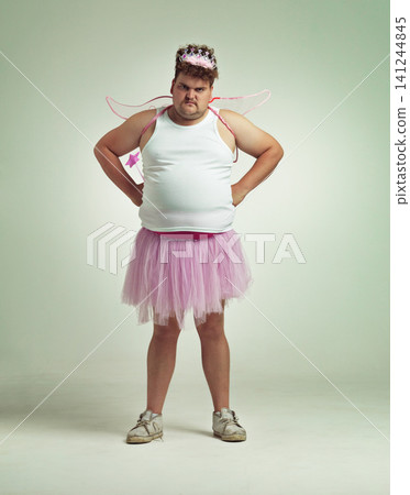 Fairy, costume and portrait of man in studio with magic, wand and wings on angry plus size model. Cosplay, character and dress up for role play on white background, mockup and space for fantasy Fairy, costume and portrait of man in studio with magic, wand and wings on angry plus size model. Cosplay, character and dress up for role play on white background, mockup and space for fantasy 141244845