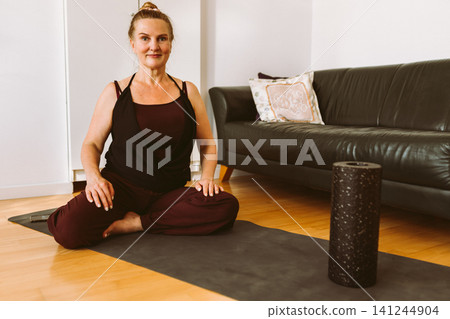 middle-aged woman doing Pilates at home middle-aged woman doing Pilates at home 141244904
