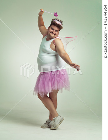 Funny, fairy and man in costume on studio with magic, wand and wings for plus size cosplay. Fantasy, character and creative model in dress up for role play on white background, mockup and space 141244954