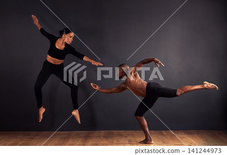 Dancers, dramatic and performance in studio with dark background, male and female ballerina being creative together. Athletics, competitive and sports for fitness, diverse people, art and movement. Dancers, dramatic and performance in studio with dark background, male and female ballerina being creative together. Athletics, competitive and sports for fitness, diverse people, art and movement. 141244973