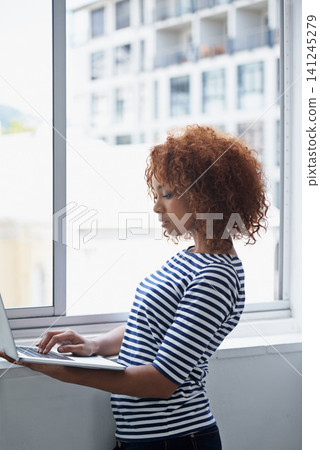 Office, window and black woman typing on laptop with research or online communication on email. Creative, employee and working with computer to scroll information or news on internet for business Office, window and black woman typing on laptop with research or online communication on email. Creative, employee and working with computer to scroll information or news on internet for business 141245279