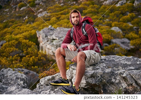 Man, mountain and hiking in nature for rest and fitness for wellness and exercise for training and adventure in environment. Young person, sitting with backpack on rock for workout and trekking Man, mountain and hiking in nature for rest and fitness for wellness and exercise for training and adventure in environment. Young person, sitting with backpack on rock for workout and trekking 141245323
