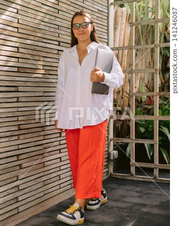 Woman in casual outfit standing outdoor near contemporary architecture Woman in casual outfit standing outdoor near contemporary architecture 141246087