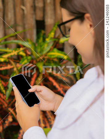 Woman using smartphone outdoor in natural setting 141246088