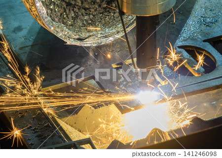 High-power laser cut machine operation cutting a high thickness metal plate with dramatic sparkling light. High-power laser cut machine operation cutting a high thickness metal plate with dramatic sparkling light. 141246098