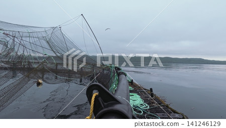 Large fish farm in the water with nets under cloudy sky as background Large fish farm in the water with nets under cloudy sky as background 141246129