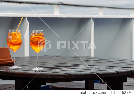 Aperol Spritz cocktail on wet ferry deck table after rain Aperol Spritz cocktail on wet ferry deck table after rain 141246259