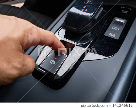 Fingers touching the handbrake switch Fingers touching the handbrake switch 141246612