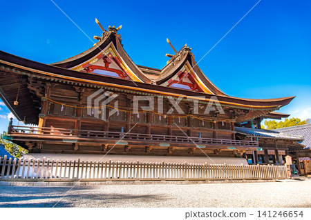 Okayama City, Okayama Prefecture: The beautiful double-gabled roof (Kibitsu style) of the main hall of the National Treasure Kibitsu Shrine, standing out against the blue sky. Okayama City, Okayama Prefecture: The beautiful double-gabled roof (Kibitsu style) of the main hall of the National Treasure Kibitsu Shrine, standing out against the blue sky. 141246654