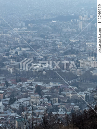 Dense urban area with residential and commercial buildings under light haze. Dense urban area with residential and commercial buildings under light haze. 141246669