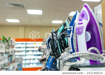 A Colorful Display of Irons in a Retail Store Featuring Various Models and Designs for Different Fabrics and Easy Use A Colorful Display of Irons in a Retail Store Featuring Various Models and Designs for Different Fabrics and Easy Use 141246814