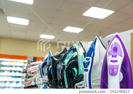 A Display of Various Steam Irons in a Retail Store Showcasing Different Designs and Colors for Home Appliance Enthusiasts A Display of Various Steam Irons in a Retail Store Showcasing Different Designs and Colors for Home Appliance Enthusiasts 141246815
