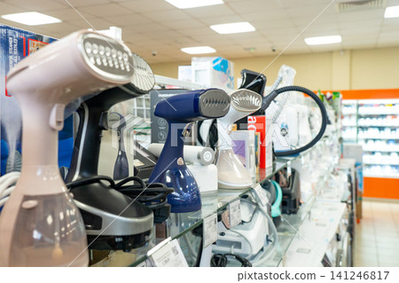 A Diverse Collection of Modern Steam Irons and Clothing Steamers Displayed in a Well-Organized Retail Store Showcase A Diverse Collection of Modern Steam Irons and Clothing Steamers Displayed in a Well-Organized Retail Store Showcase 141246817