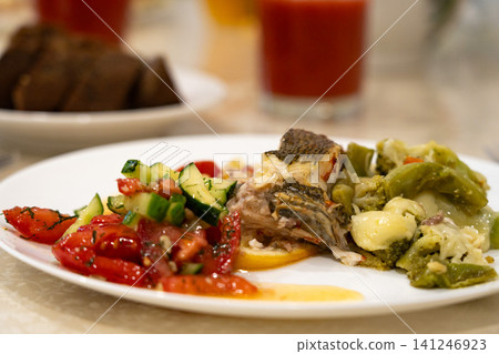 A Colorful and Wholesome Plate of Fresh Fish Accompanied by Vibrant Vegetables and Savory Sides for a Balanced and Delicious Meal A Colorful and Wholesome Plate of Fresh Fish Accompanied by Vibrant Vegetables and Savory Sides for a Balanced and Delicious Meal 141246923
