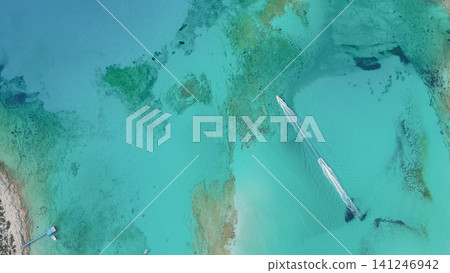 Top down drone view of two speedboats leaving white foam trails on crystal clear turquoise sea water with scenic reef sandy bottom in Balos lagoon Crete Top down drone view of two speedboats leaving white foam trails on crystal clear turquoise sea water with scenic reef sandy bottom in Balos lagoon Crete 141246942