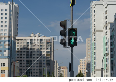 A Vibrant Urban Scene Featuring a Green Pedestrian Signal Against a Backdrop of Modern High-Rise Buildings Under a Clear Blue Sky A Vibrant Urban Scene Featuring a Green Pedestrian Signal Against a Backdrop of Modern High-Rise Buildings Under a Clear Blue Sky 141246956