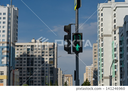 A Green Pedestrian Signal in a Modern Urban Environment with Tall Residential Buildings Under a Clear Blue Sky A Green Pedestrian Signal in a Modern Urban Environment with Tall Residential Buildings Under a Clear Blue Sky 141246960