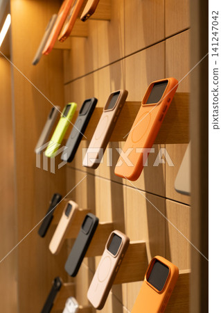 A Display of Colorful Phone Cases on Wooden Shelves Showcasing Modern Design and Functionality in a Retail Environment A Display of Colorful Phone Cases on Wooden Shelves Showcasing Modern Design and Functionality in a Retail Environment 141247042