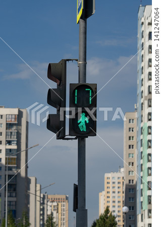 Green Pedestrian Signal Illuminating City Streets, Indicating Safe Passage and Providing a Clear Signal for Walkers Amidst Urban Architecture 141247064
