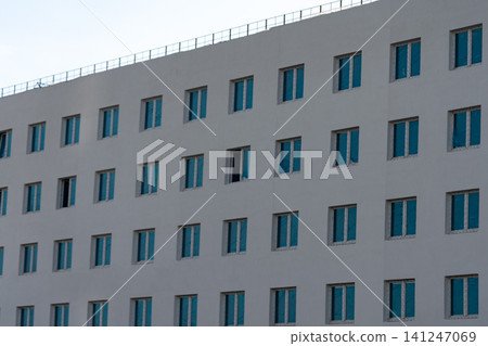 Contemporary Architectural Facade Showcasing Uniform Windows with Unique Openings and Modern Design Elements Contemporary Architectural Facade Showcasing Uniform Windows with Unique Openings and Modern Design Elements 141247069