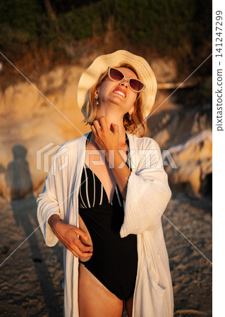 Woman scratching neck from itching skin irritation on beach Woman scratching neck from itching skin irritation on beach 141247299