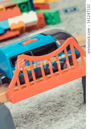 Train on plastic bridge with wooden toy tracks Train on plastic bridge with wooden toy tracks 141247332