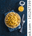 Delicious plant-based pasta dish with homemade dairy-free chia cheddar cheese sauce. Pasta with vegan creamy chia cheddar sauce on dark blue background. Vertical. Copy space 141247399