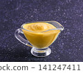 Delicious plant-based dairy-free cheddar cheese sauce with chia seeds served in glass bowl. Vibrant purple background with copy space. Creamy Cheddar sauce with chia seeds on dark background 141247411