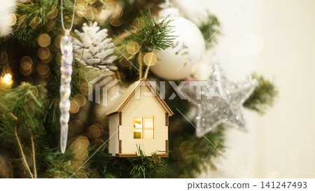 A small wooden house on a Christmas tree A small wooden house on a Christmas tree 141247493