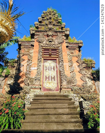 A beautiful traditional architectural sculpture gate at the Ubud Royal Palace in Bali, Indonesia. A beautiful traditional architectural sculpture gate at the Ubud Royal Palace in Bali, Indonesia. 141247629