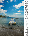 Floating Pier with Boats and Jet Skis in Turquoise Sea Near Mountains 141247640