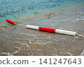 Bright Red and White Beach Safety Buoys Floating Near Shoreline 141247643