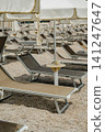 Close Up Beach Lounge Area with Sunbeds and Umbrellas for Summer Vacation 141247647