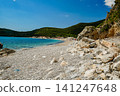 Wide Rocky Beach in Scenic Bay with Green Mountains and Blue Sea 141247648