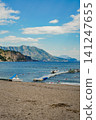 Sandy Beach with Floating Pier and Pedal Boat Against Mountain Landscape 141247655