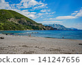 Wide Sandy Beach with Turquoise Sea and Green Mountains on Sunny Summer Day 141247656